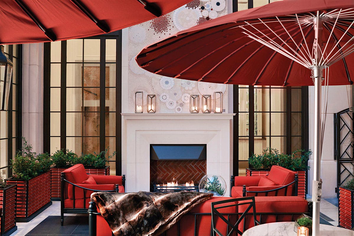 While technically outside, the open-air Corinthia Hotel Garden Lounge is surrounded on all sides by walls. A fireplace provides some of the heat.