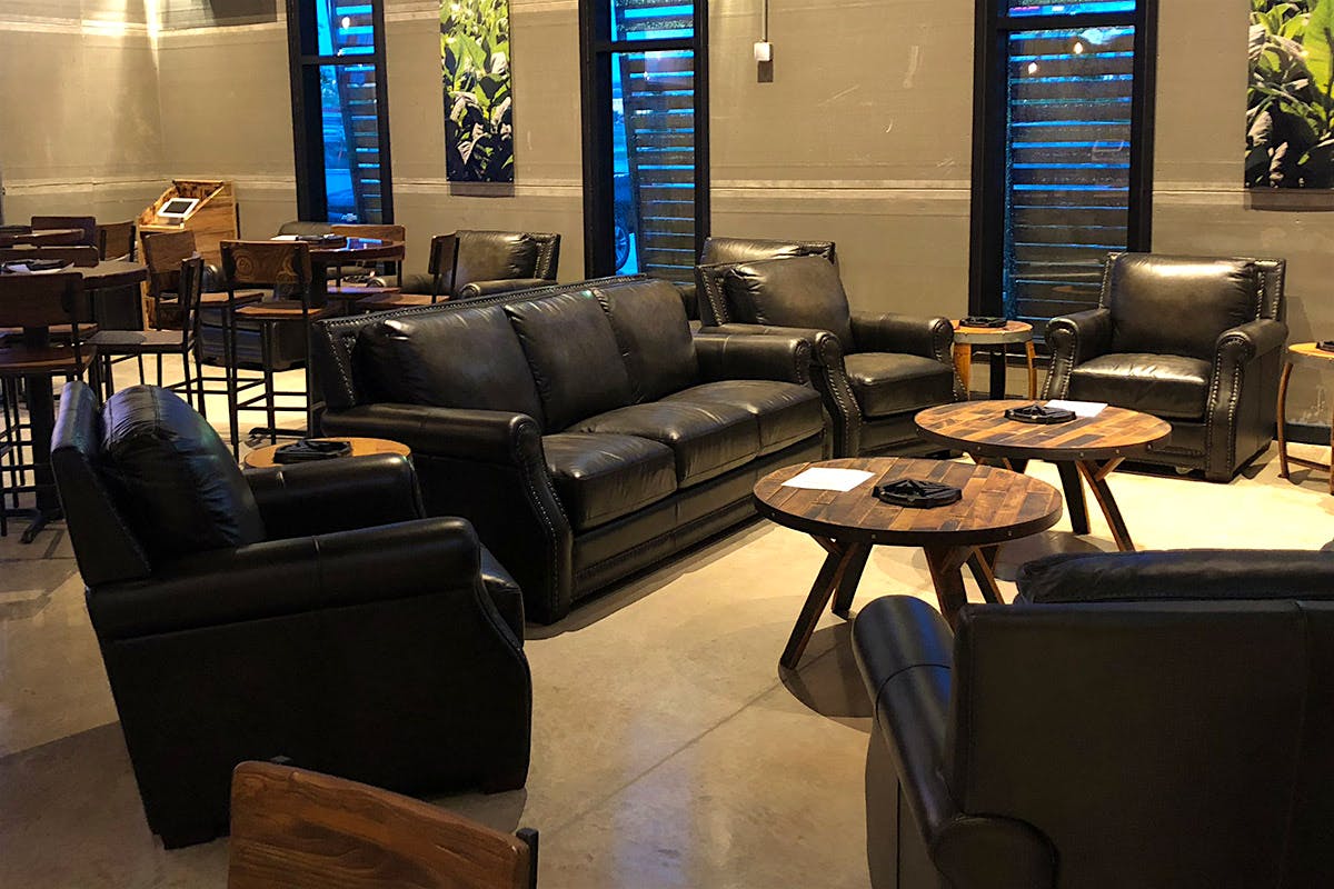 The expansive indoor lounge features plush leather chairs and bar tables.