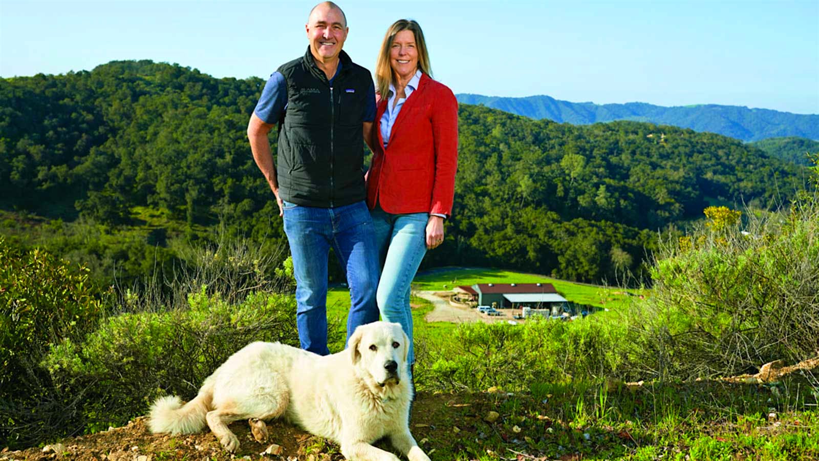 The owners with a large white dog at their feet