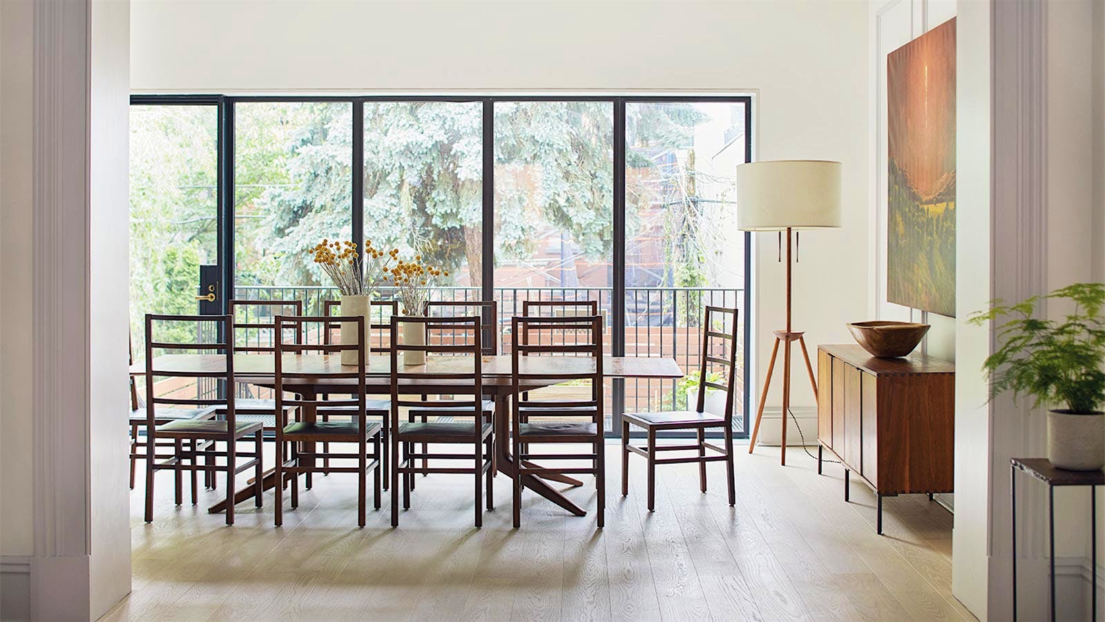 Light-filled dining room, with table in front of floor-to-ceiling windows. Photo by Ty Cole