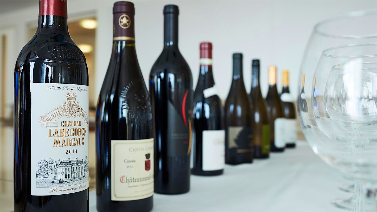 A collection of wine bottles to be shared includes Bordeaux and Châteauneuf-du-Pape reds.
