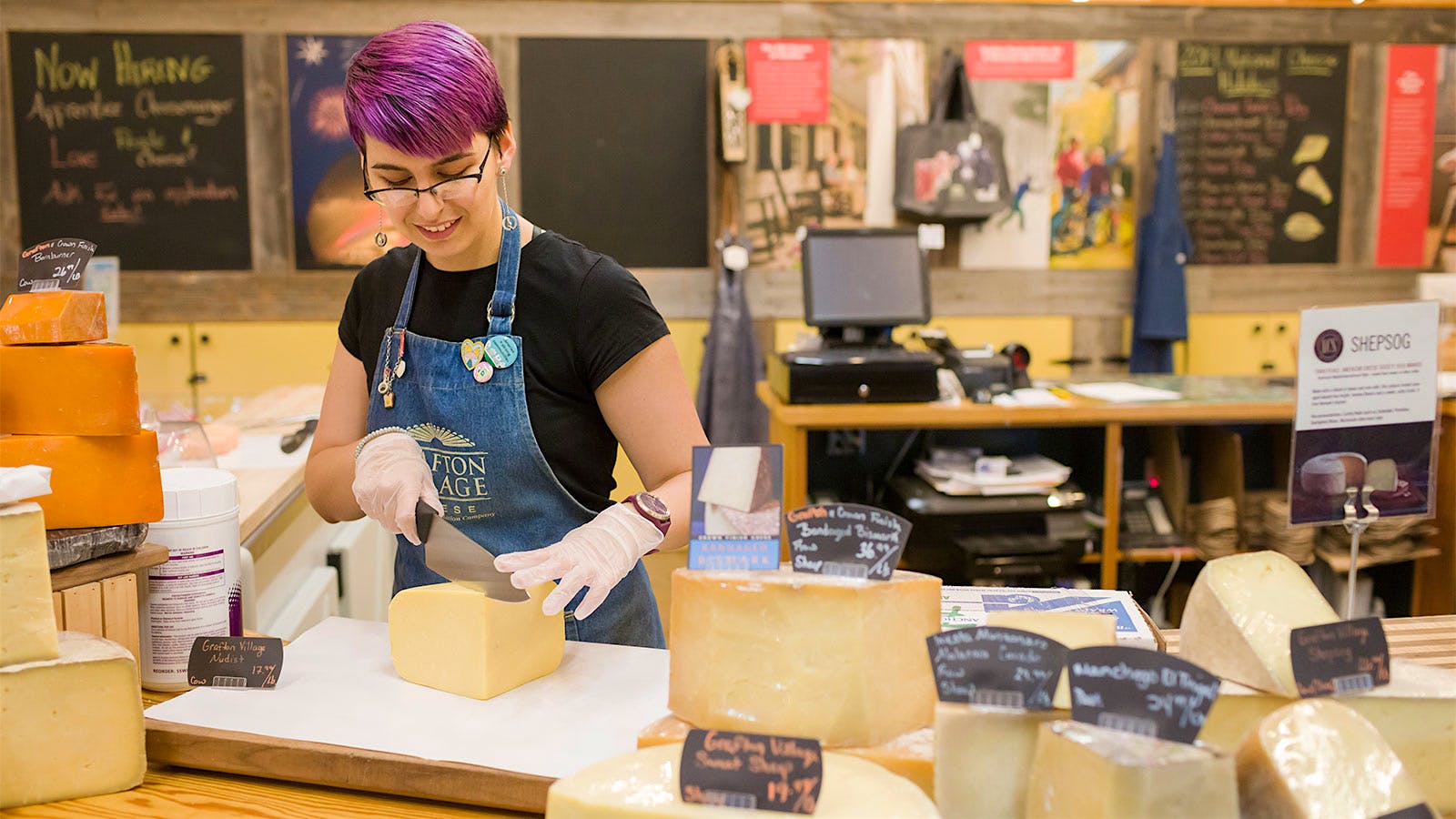 An employee cutting cheese at Grafton Village Cheese Co.