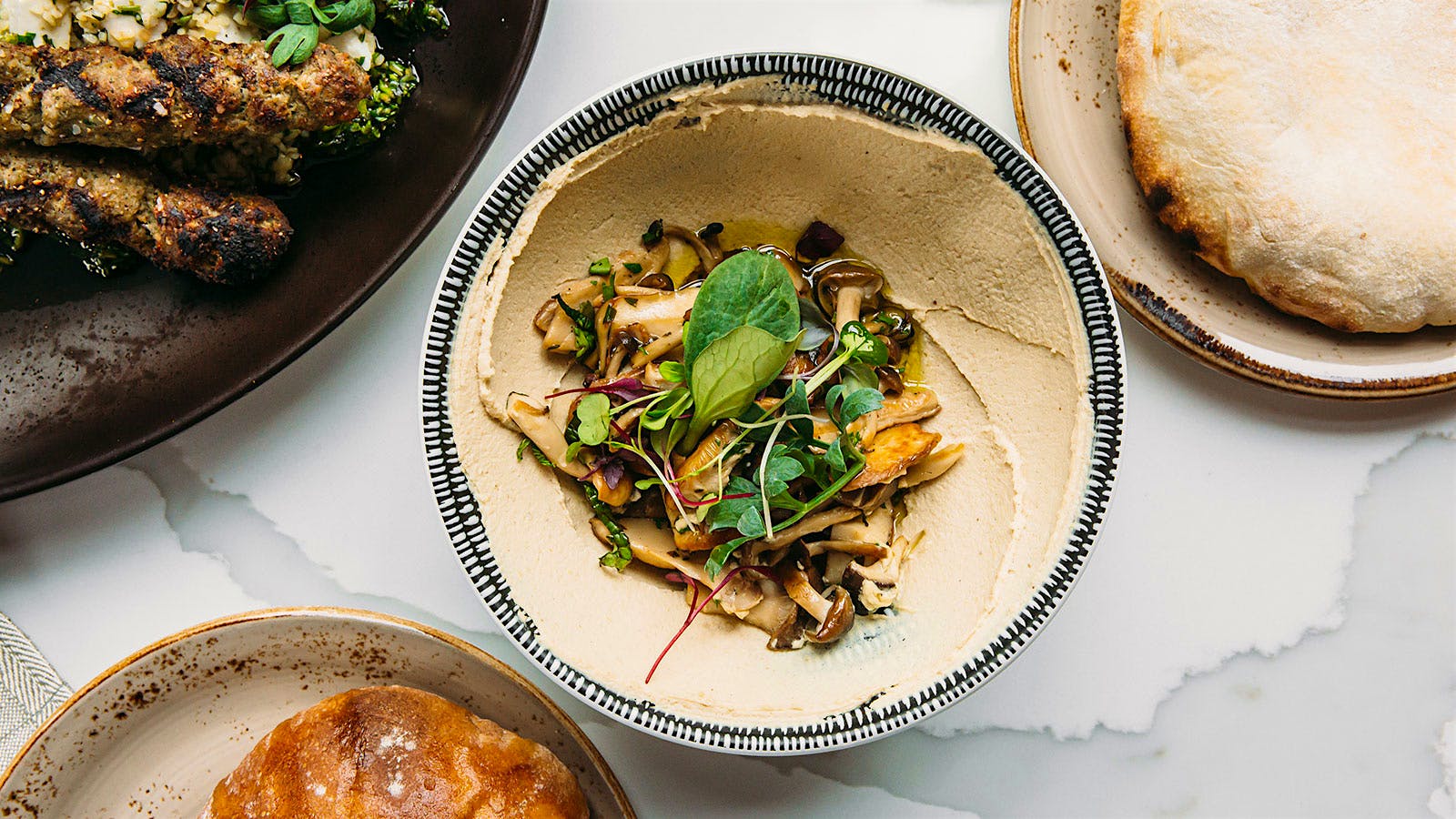 Hummus with other food dishes surrounding