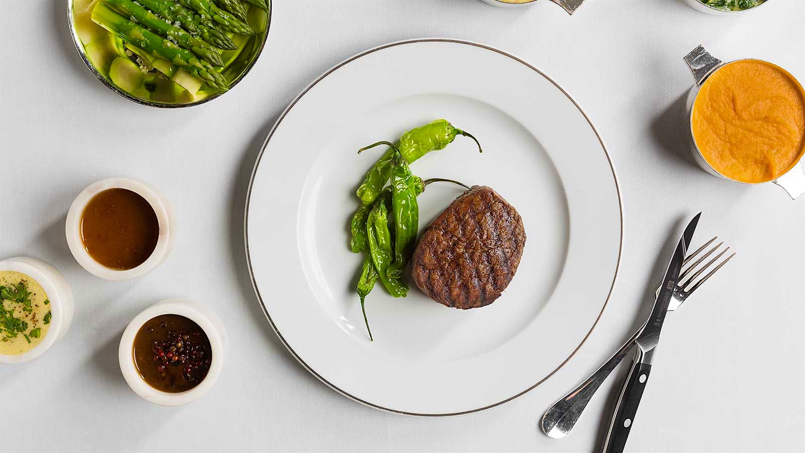 A filet mignon with peppers and sides at Prime Steakhouse