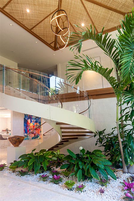 Entryway with palm tree, rock garden and spiral staircase