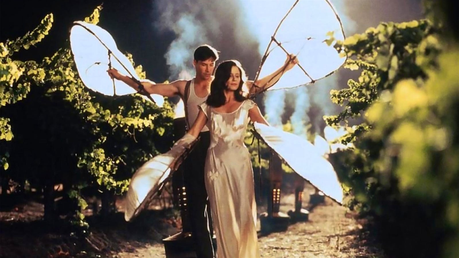 A Walk in the Clouds movie still: Keanu Reeves and Aitana Sánchez-Gijón walk in a vineyard at night