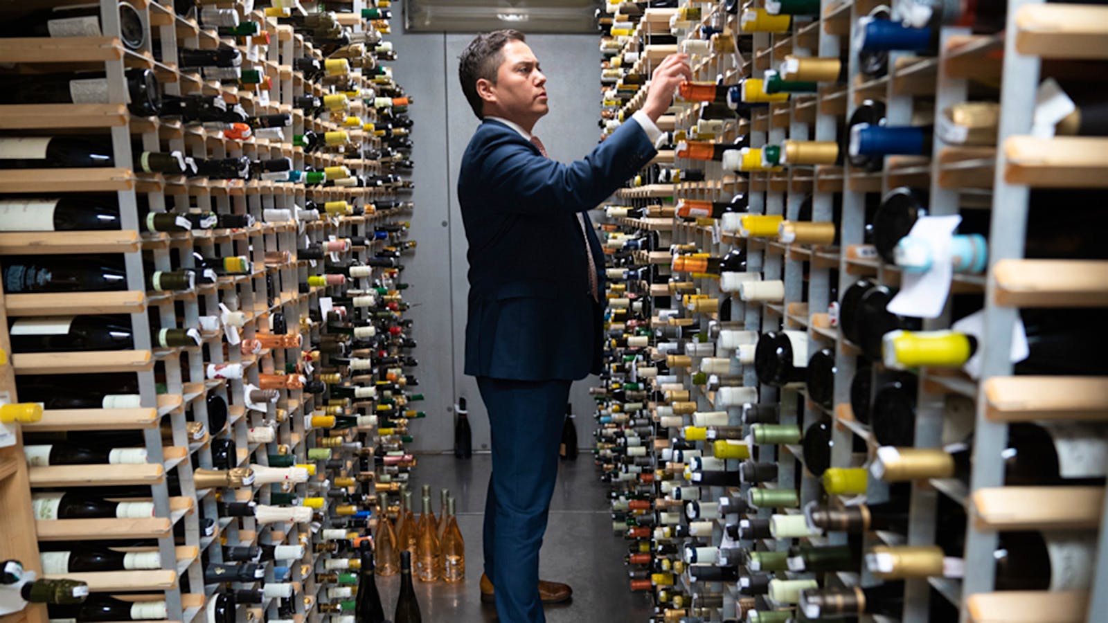 Fiola’s wine director Casper Rice selecting a bottle in the cellar