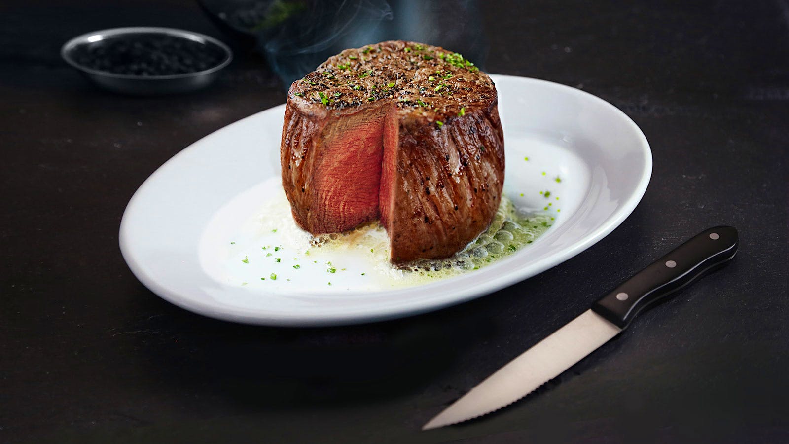 Steak on a white plate next to a knife at Ruth’s Chris Steak House