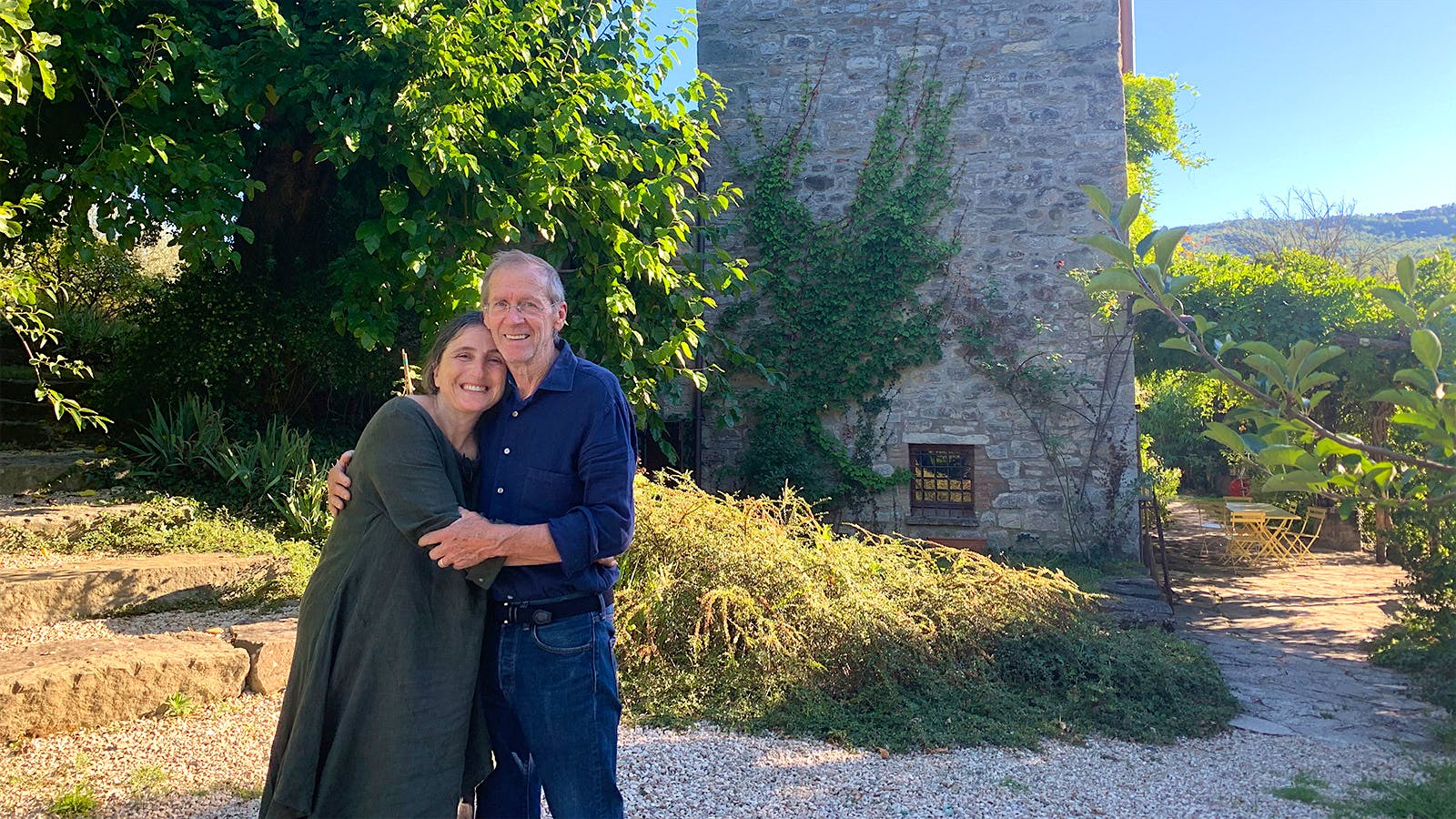 Claudia Rizza and Ev Thomas in front of the ancient stone tower on their Umbrian property