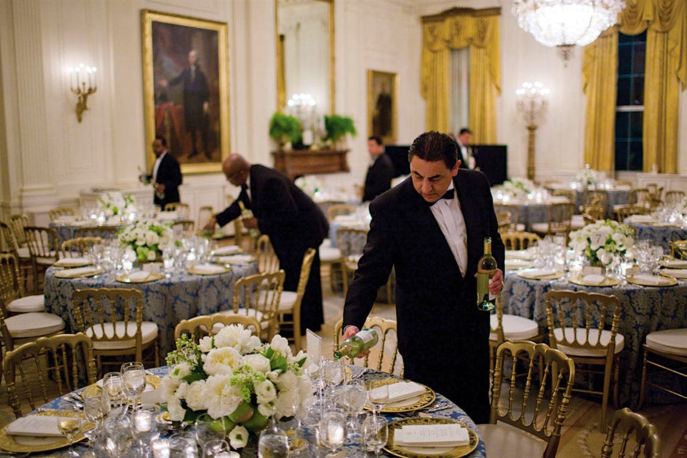 White House butlers pour white wine in the East Room before a dinner for congressional committee chairs in 2009.