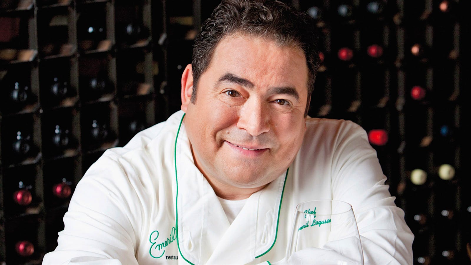 Chef Emeril Lagasse in front of a wine cellar