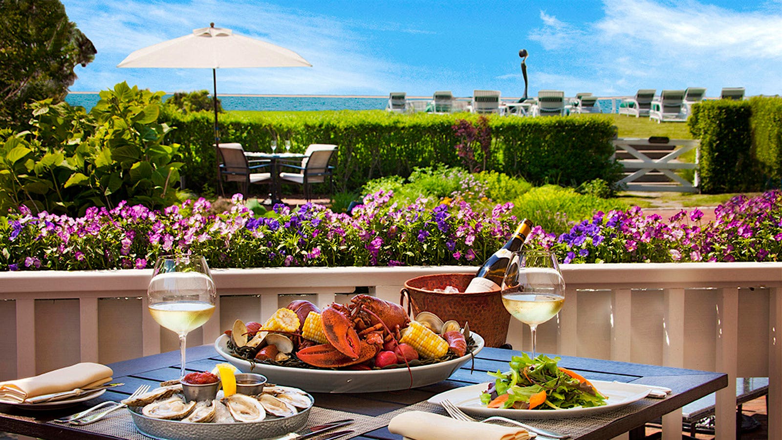 A table for two with seafood, salad and white wine at Topper’s at the Wauwinet
