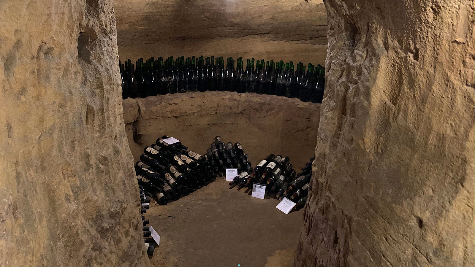 Rows and pyramids of bottles in Ferraris' ancient underground, earthern wine cellars