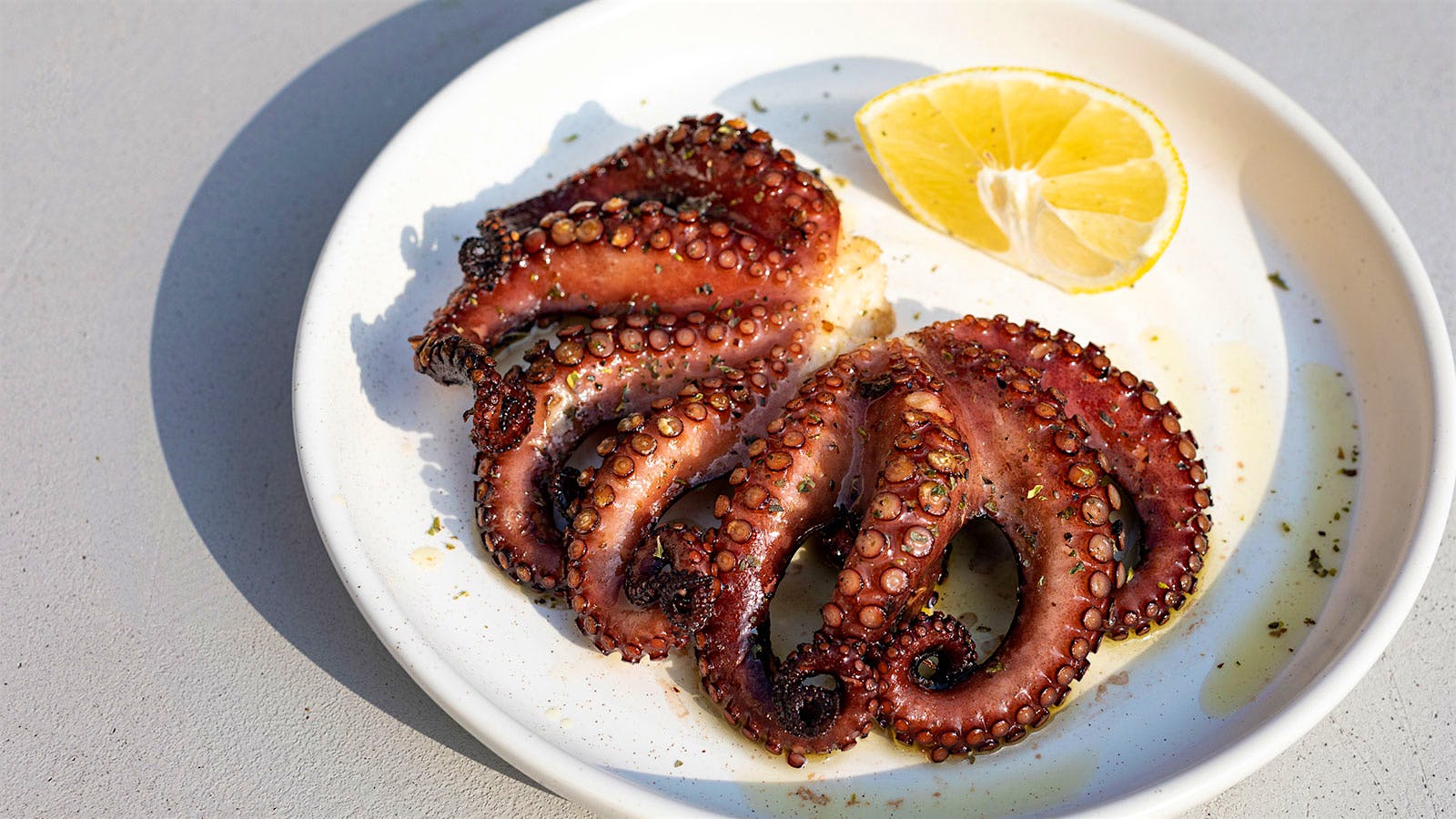 Grilled octopus served with a lemon wedge