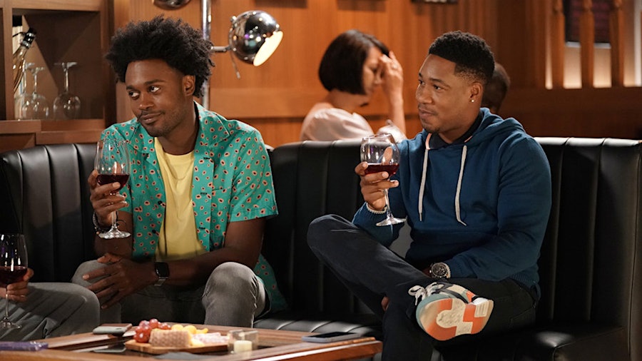 Noah (Echo Kellum, left) and Anthony (Aaron Jennings) enjoy a glass of red wine on Grand Crew.
