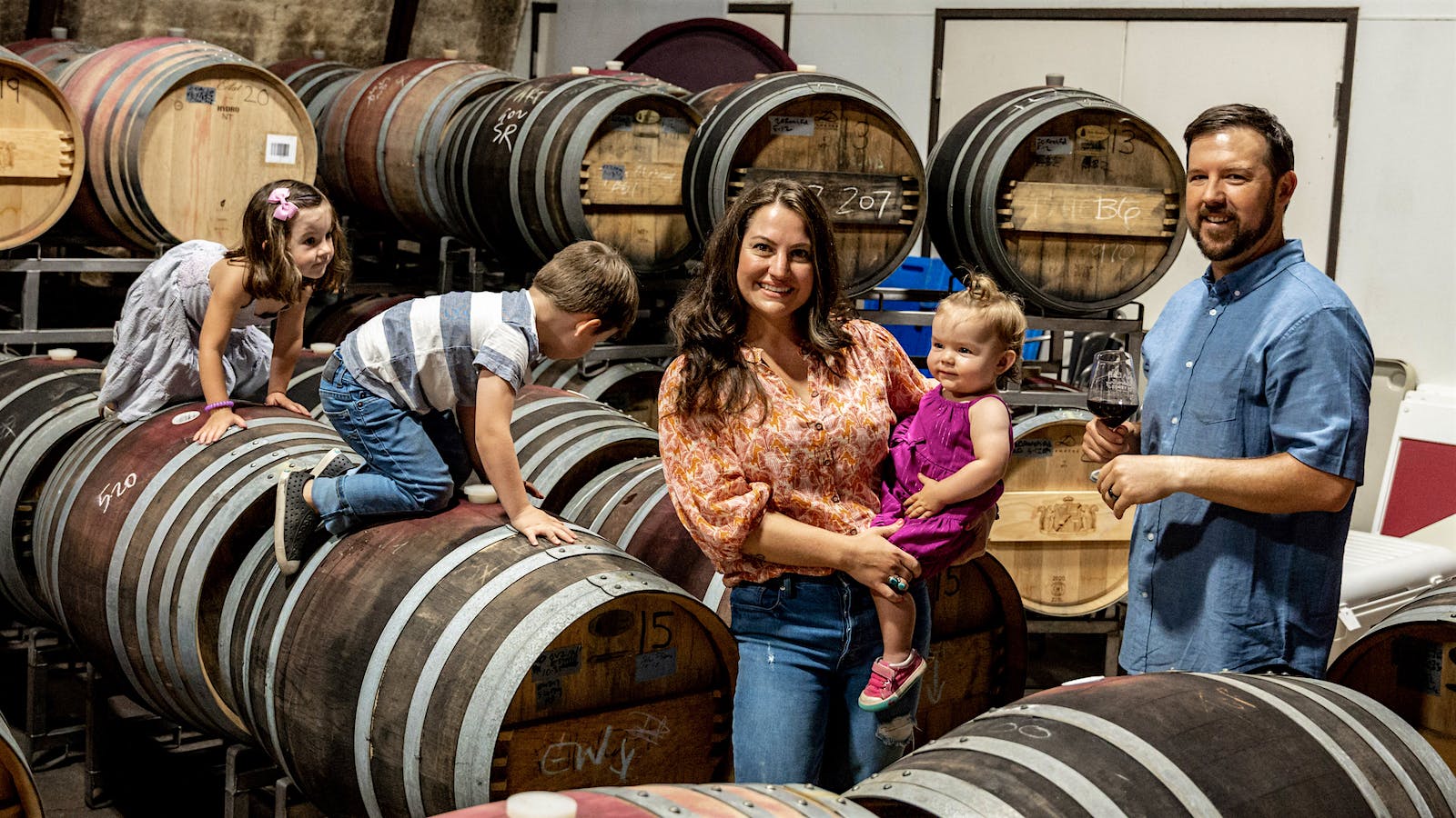  Andrew and April Nalle of Sonoma's Nalle Winery enjoy time in the winery's barrel room with their three children.] 