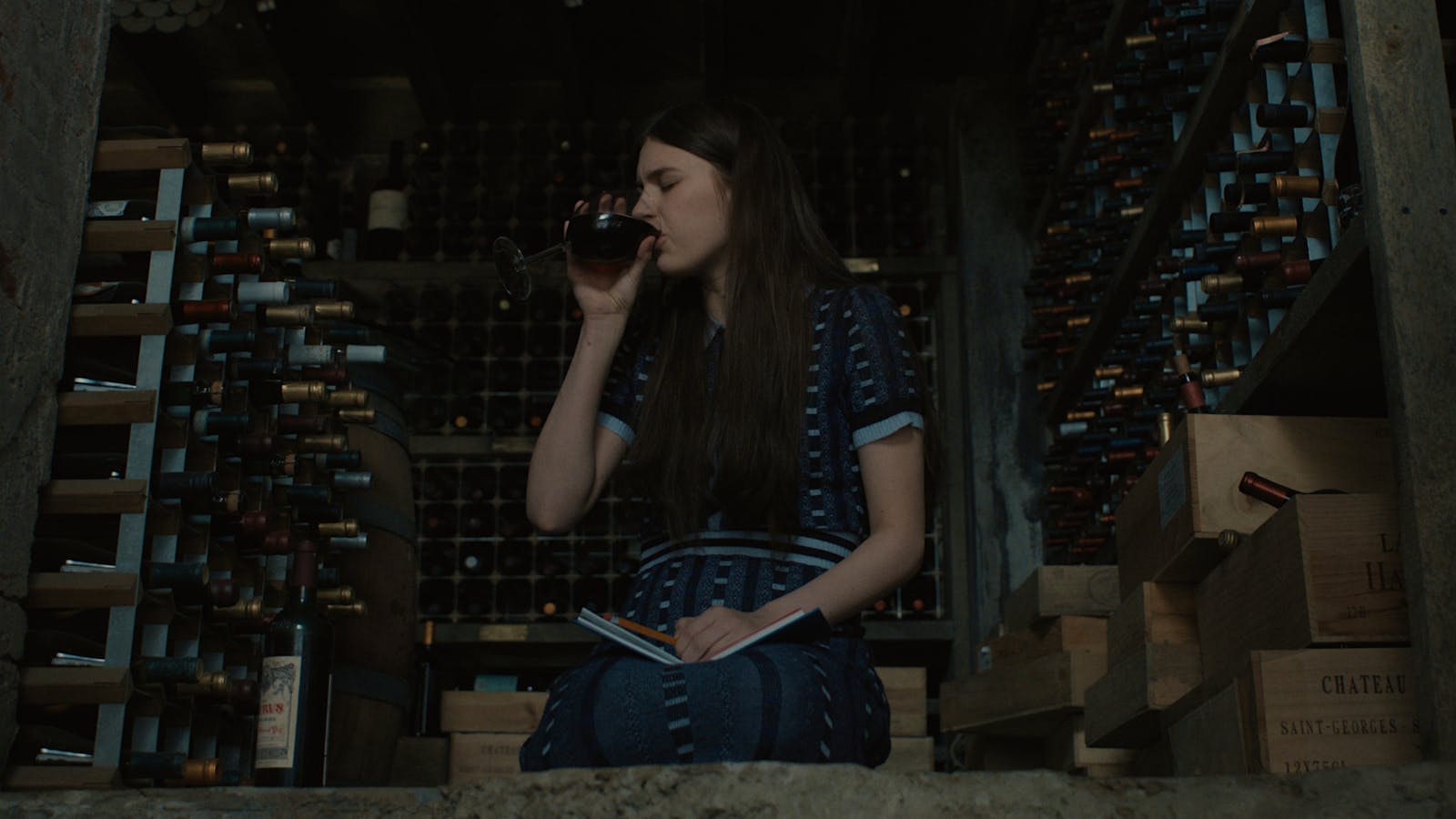  Nanny Leanne sits in a basement wine cellar drinking a bottle of 1996 P&eacute;trus in a scene from the season 3 premiere of Servant on Apple TV.] 