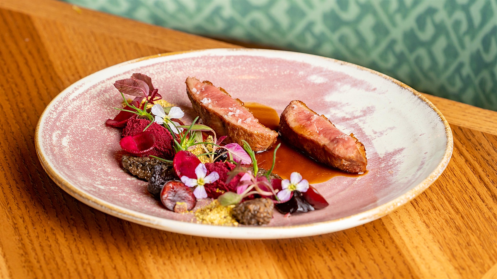  A beautifully plated dish of roasted Peking duck breast with beets, Bing cherries, Sierra morels and hazelnut dukkah