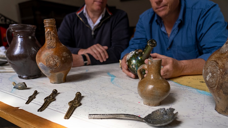 Diving brothers Julian and Lincoln Barnwell examine a few of their finds recovered from the wreck of the <em>HMS Gloucester</em>.