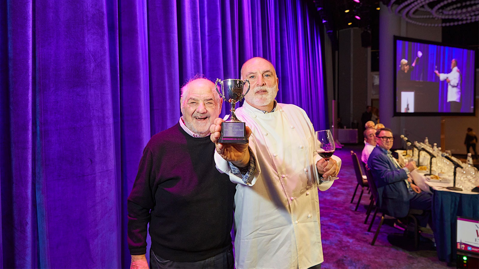  Chef José Andres holds the trophy as close to the camera as possible while he has arm around Marvin R. Shanken
