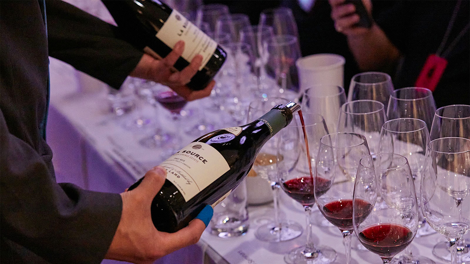  Server pouring a bottle of Evening Land La Source Seven Springs Estate Pinot Noir 2019 for a guest at the 2022 New York Wine Experience