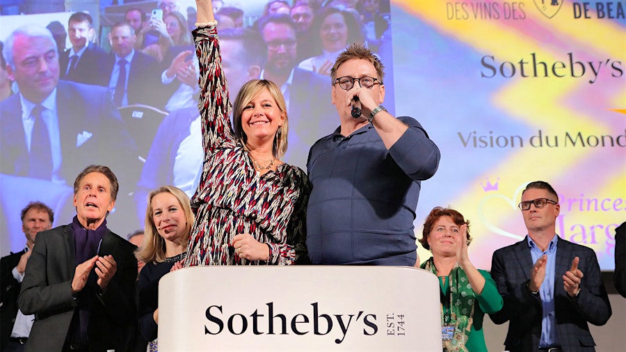 French TV presenter Flavie Flament and actor Benoit Magimel cheer on the crowd of wine industry members bidding for Burgundy for a good cause.
