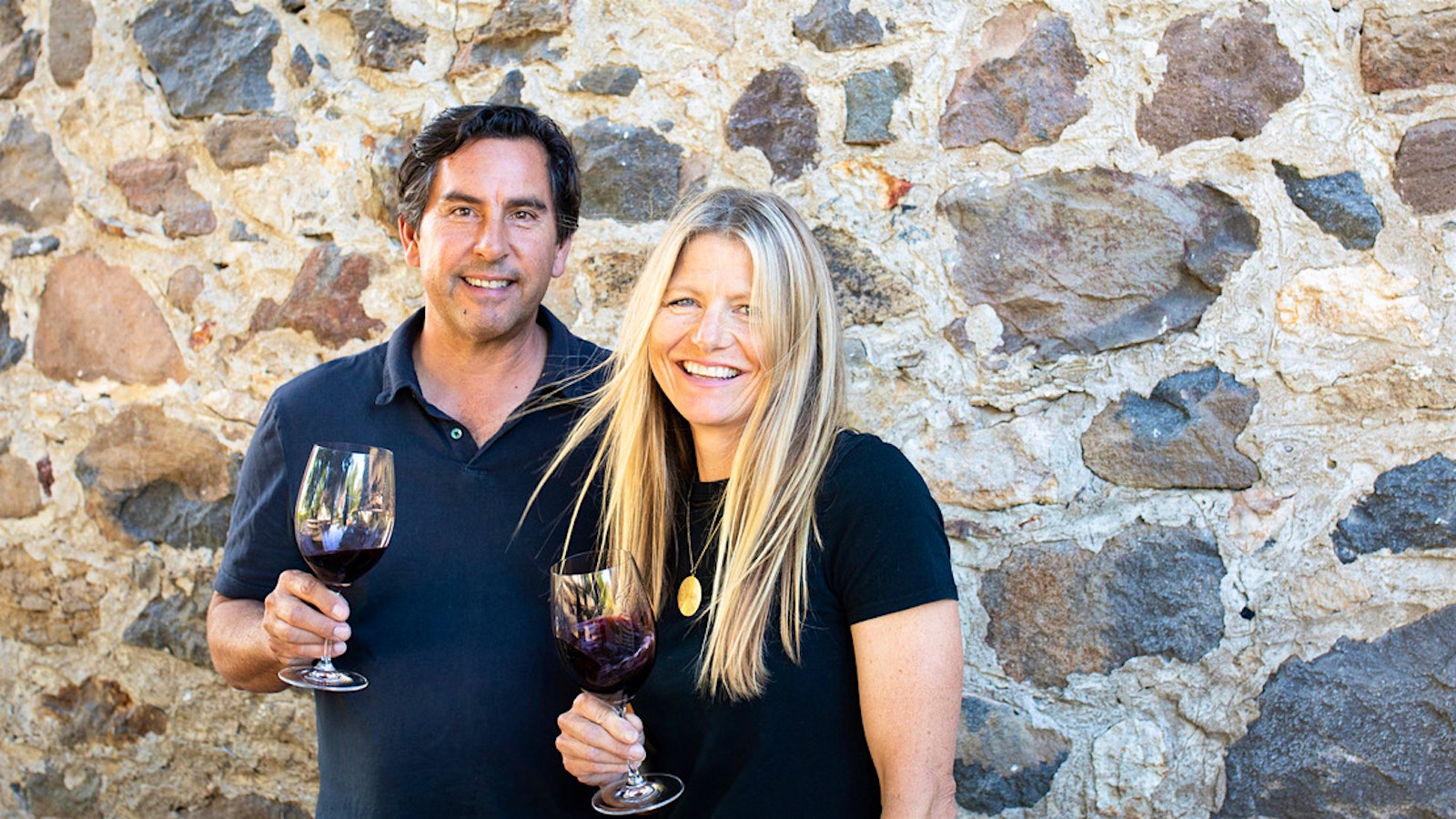  Andy Erickson and Annie Favia pose together holding glasses of red wine