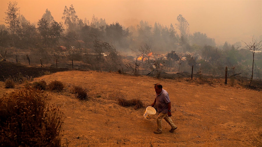 A man tries to contain a fire in Santa Juana, Concepcion province, Chile, as wildfires blaze across the region, threatening towns and vineyards.