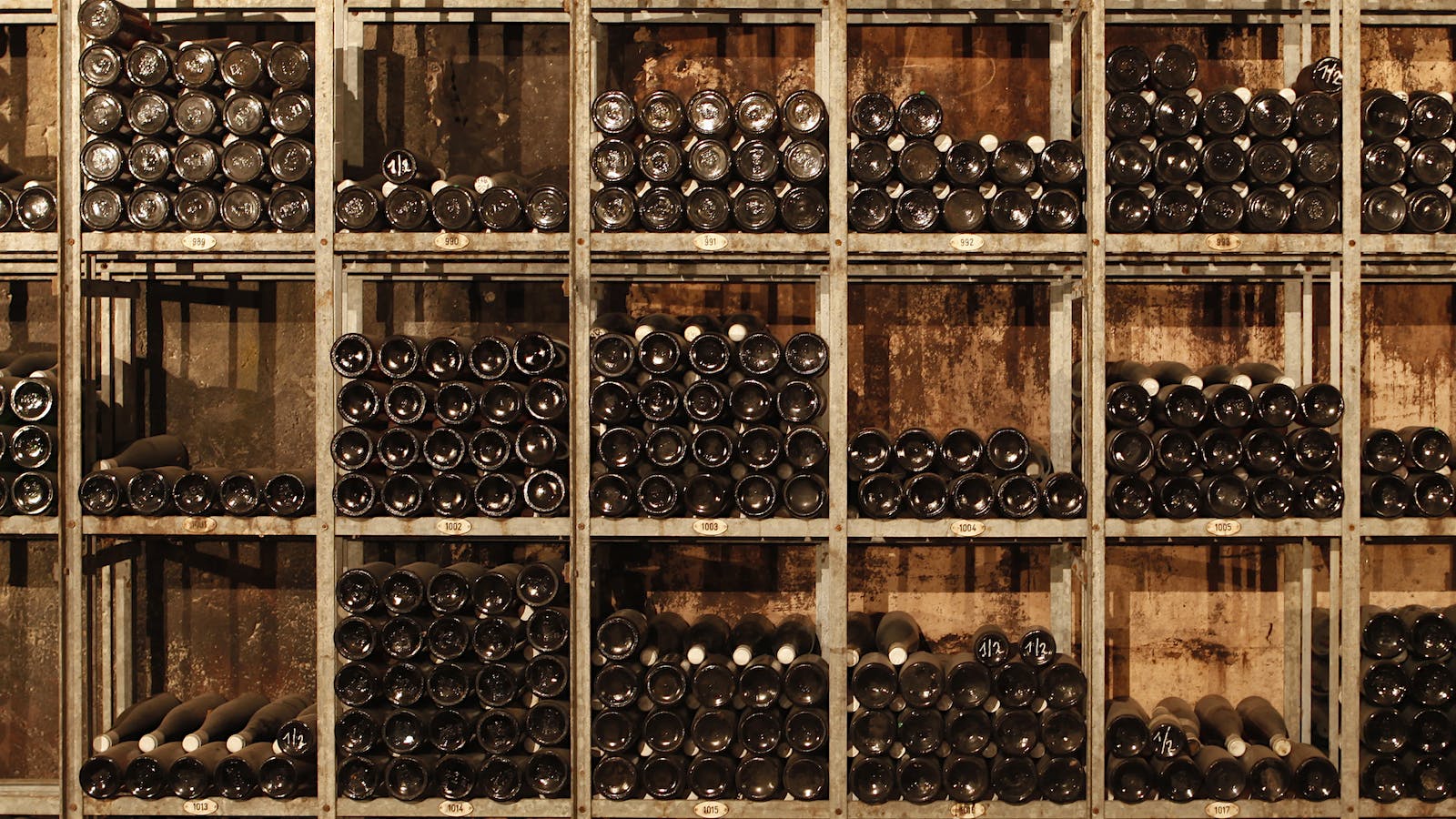 Dozens of wine bottles stacked on their side in a wine cellar rack