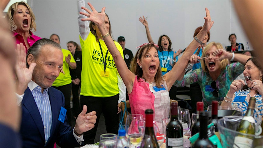 A winning bidder celebrates snagging a lot at this year's Naples Winter Wine Festival, which brought top winemakers to Southwest Florida.