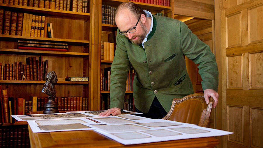 Prince Robert of Luxembourg reviews pages in Château Haut-Brion's impressive library.