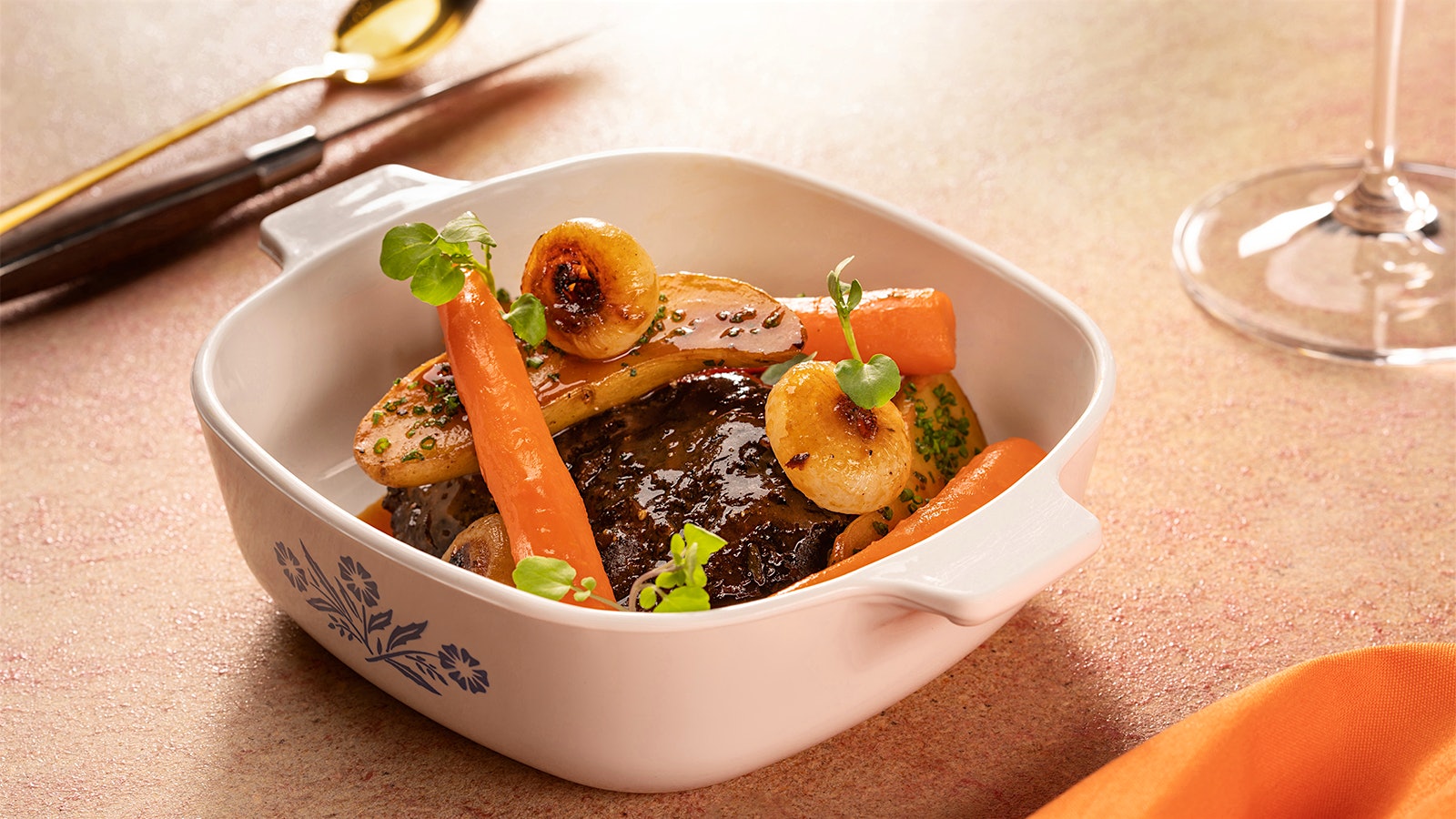  A Corningware blue cornflower casserole dish holding the Retro by Voltaggio version of pot roast with wagyu beef checks, glazed carrots and fingerling potatoes