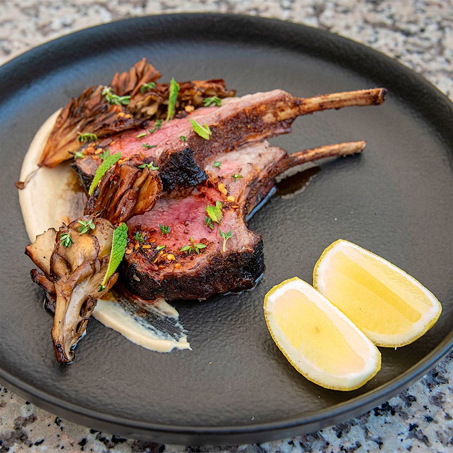 New York City chef Kwame Onwauchi mingles influences and ingredients in unexpected ways; in this recipe, he brings together earthy mushrooms, fiery chili crisp and nutty hummus to complement gamy lamb.