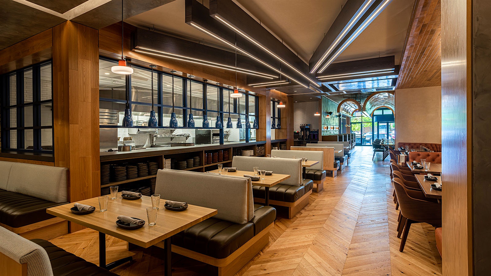  The dining room at Ramsay's Kitchen in Naperville, Ill., with wooden design elements and gray and brown leather benches