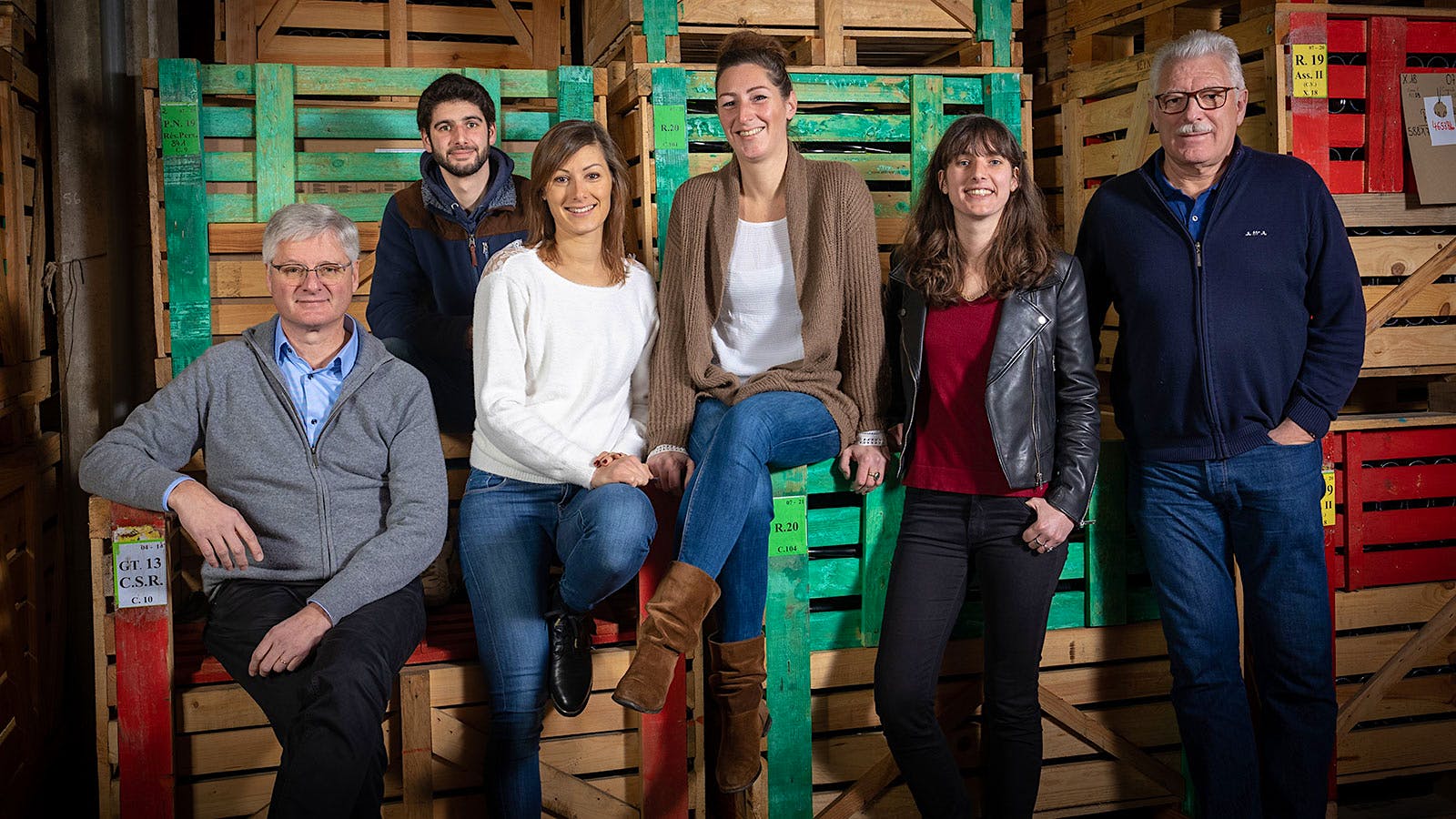 Portrait of the 12th and 13th generations of Trimbach family members in front of crates at the winery: From left, Jean, Julien,  Frédérique, Anne, Pauline and Pierre