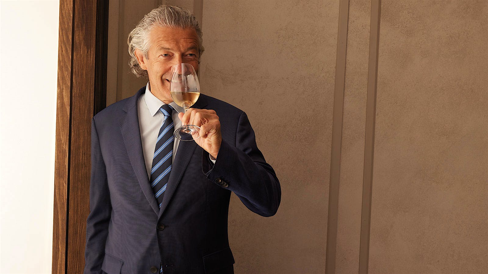 Languedoc vintner Gérard Bertrand holding a glass of rosé to his nose at the 2023 New York Wine Experience