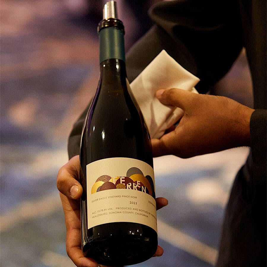  A bottle of Ferren&rsquo;s Pinot Noir Sonoma Coast Silver Eagle Vineyard 2021, held by a Wine Experience staff member 