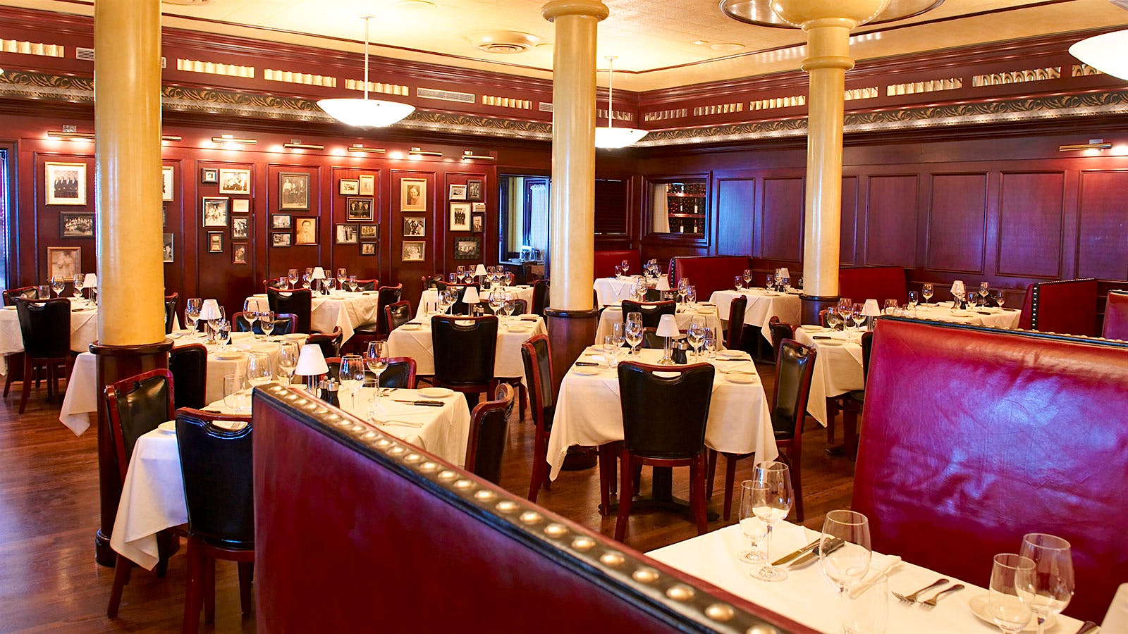  The dining room at the Pappas Bros. Houston Galleria, with red leather benches and seats, white columns and red-paneled walls