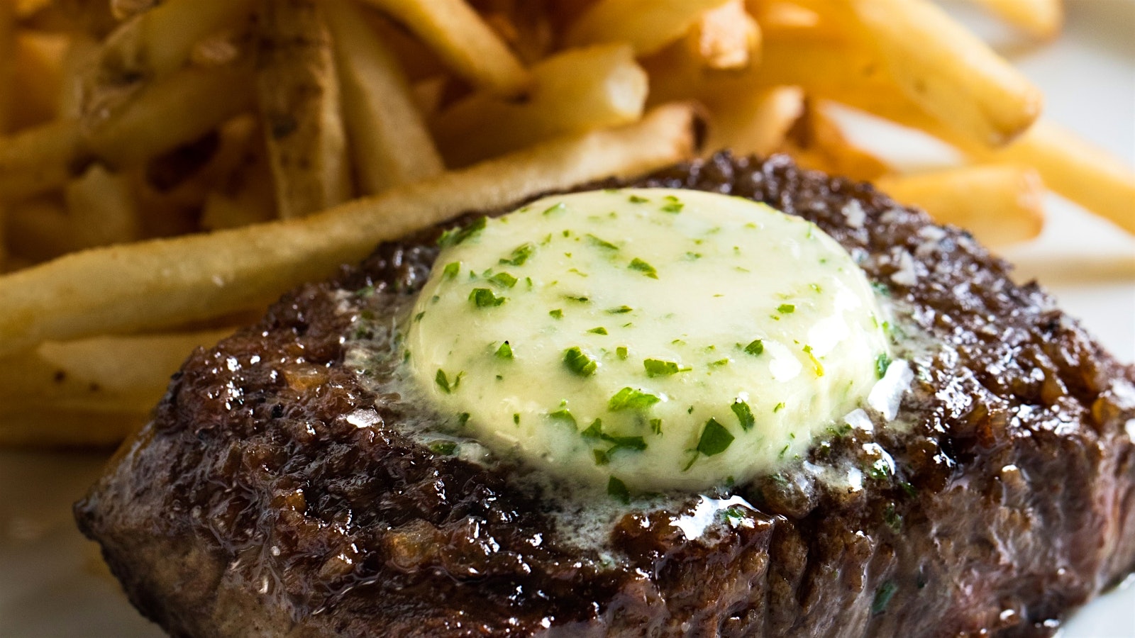  Steak frites at Bouchon Bistro in Coral Gables, Florida, with a pat of butter on top, and French fries on the plate