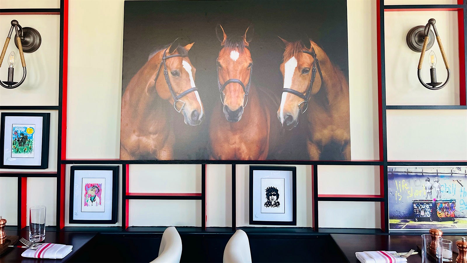  A painting of three horses, rustic lighting fixtures and other art at Red Horse by David Burke in Bernardsville, New Jersey