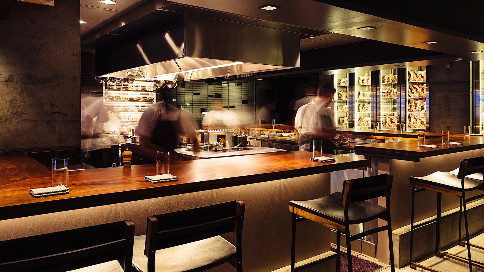  Chefs working in the open kitchen at Momofuku Ko, behind a wood-top bar