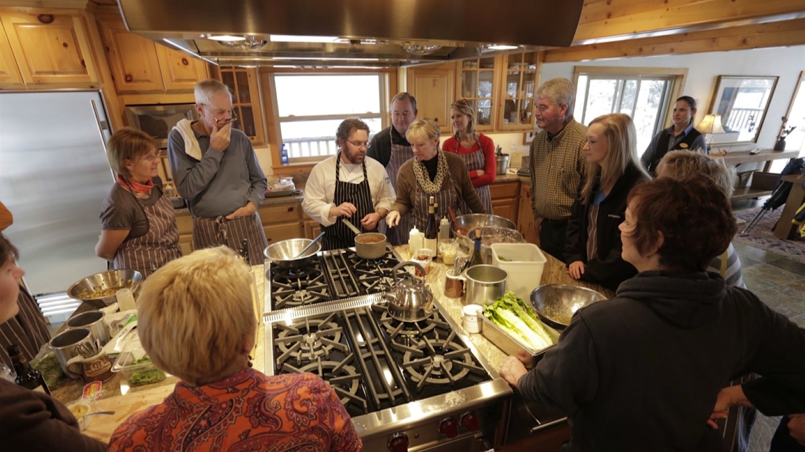  Triple Creek Ranch guests in a kitchen during a cooking class with a chef