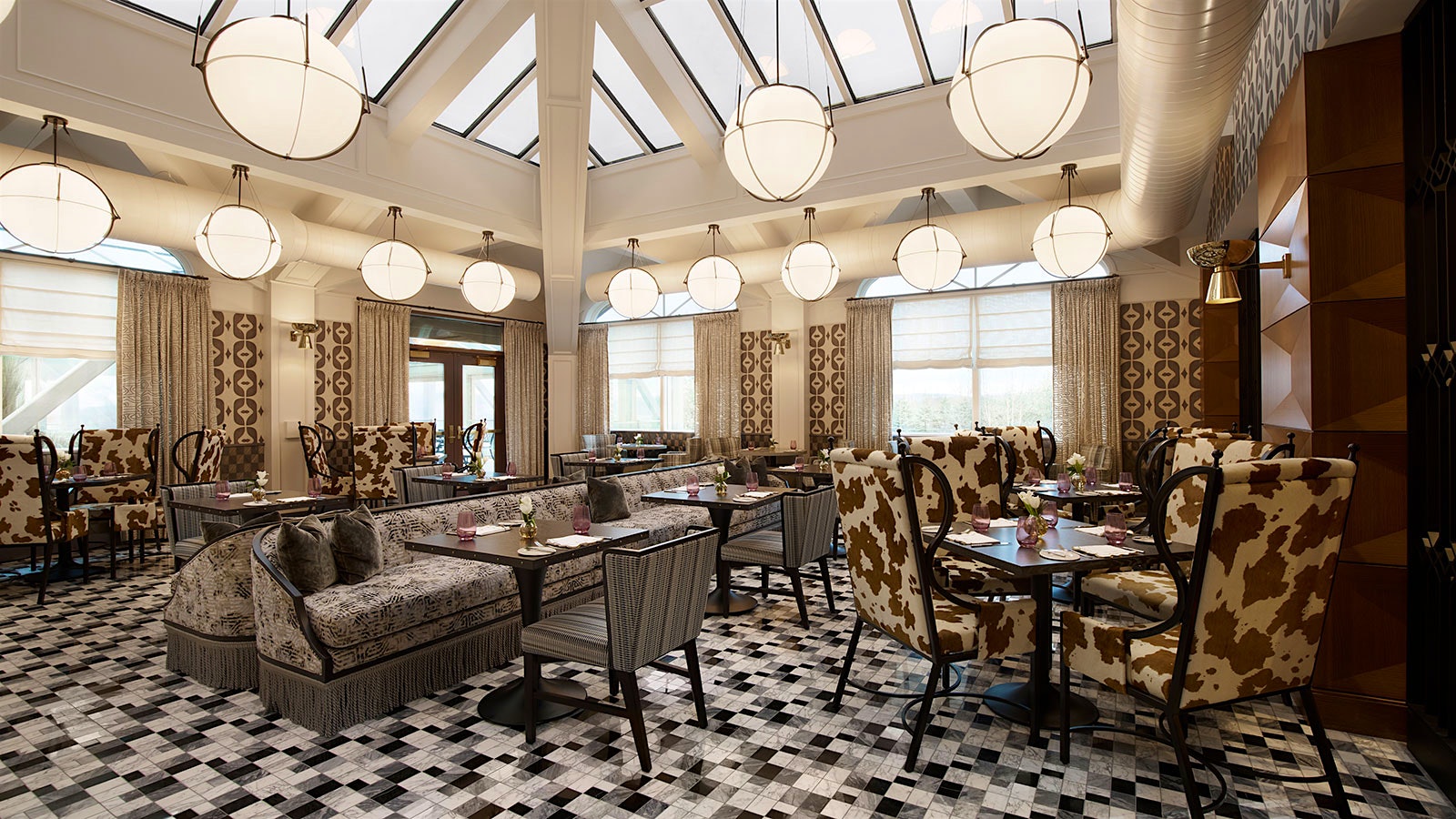  A dining room at Nemacolin's Fawn and Fable, where there are spherical lighting fixtures and cow-printed chairs