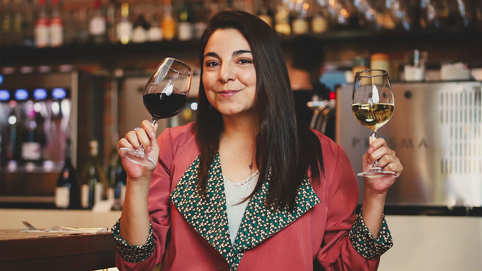  Katherine Hidalgo holding two glasses of wine in the dining room of Bocan&aacute;riz