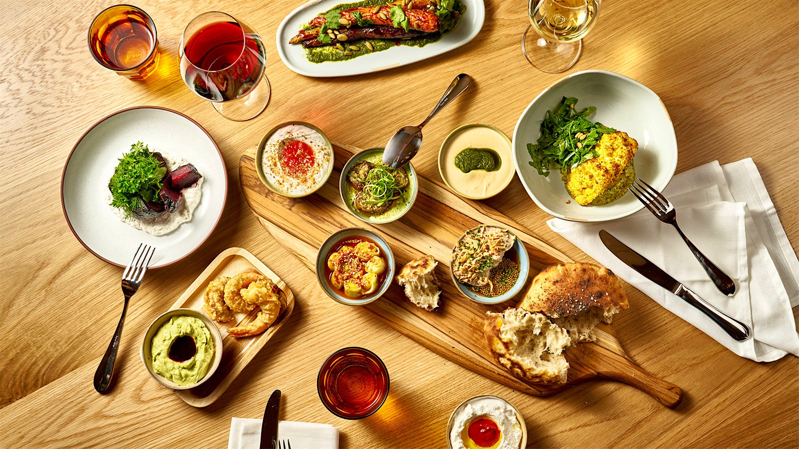  Different Israeli mezze dishes with glasses of wine.