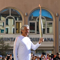 French wine legend and former rugby player Gérard Bertrand lifts the 2024 Olympic torch.French Vintners Carry the 2024 Paris Olympic Torch
