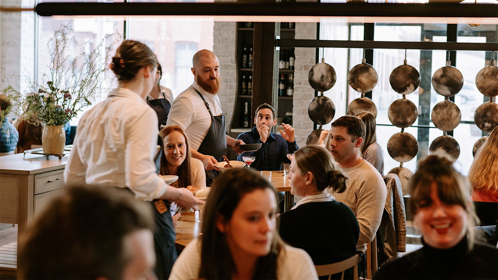 Servers moving between diners in the dining room of Twelve in Portland, Maine