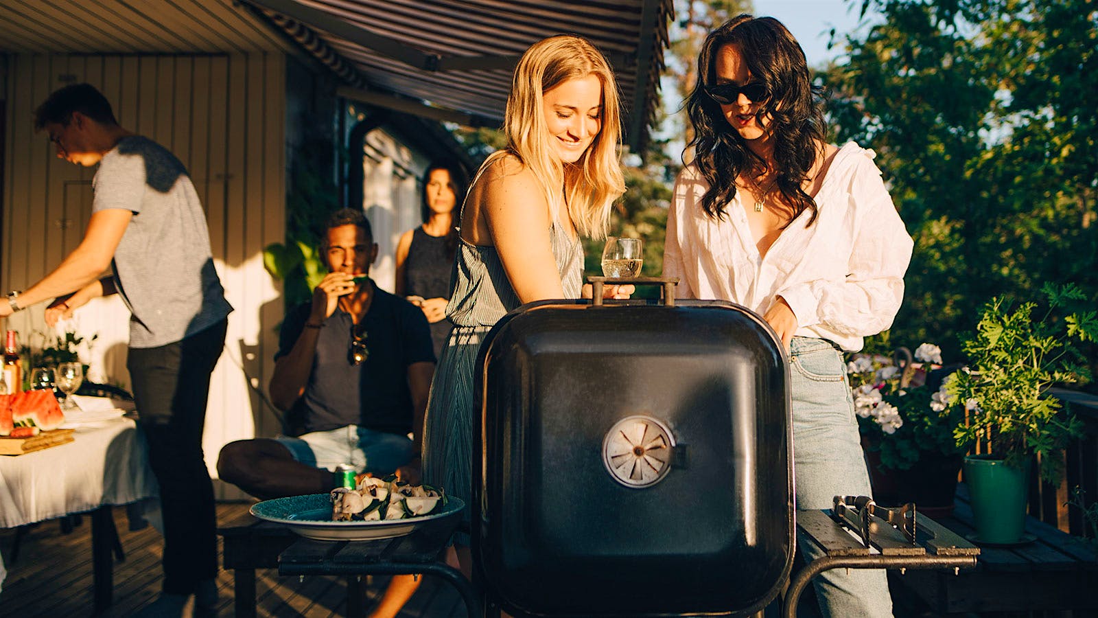 Group drinking white wine while grilling at a barbecue