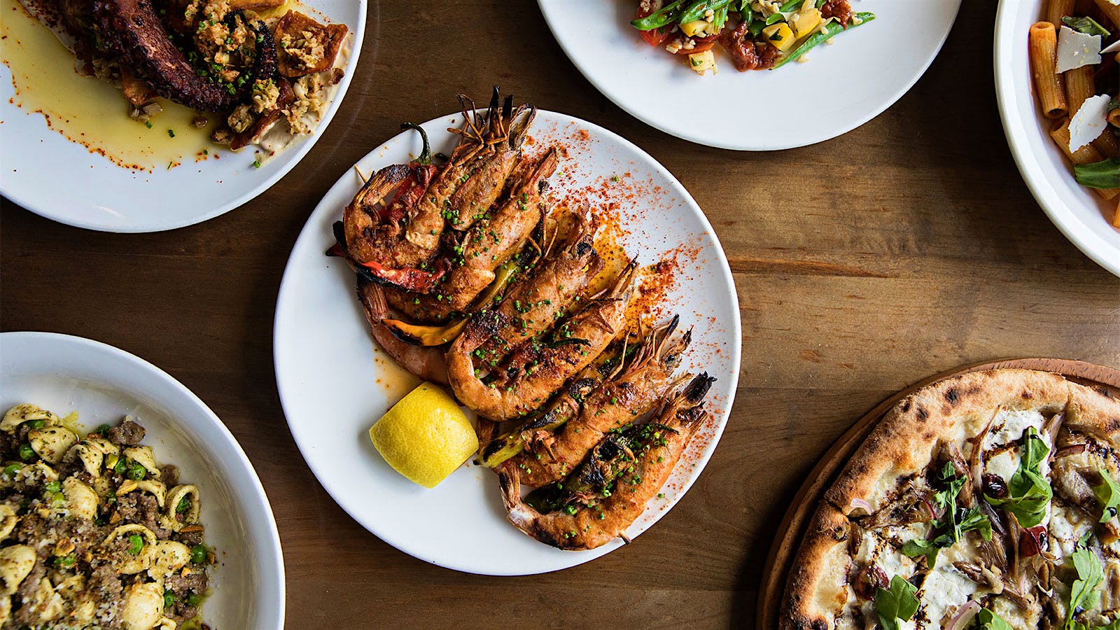 Several plates of food, including prawns, octopus, pasta and pizza, at The Obstinate Daughter in Charleston, South Carolina