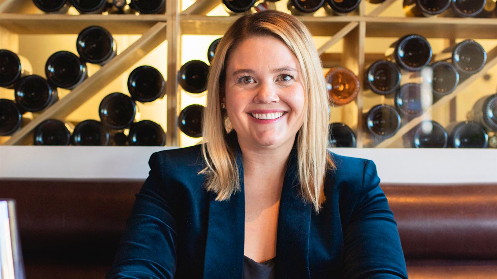 Wine director Carlin Karr in front of a wall of wine